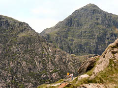 Family group on the Miners Track descending from Glaslyn with the peak of Yr Wyddfa in the background. 